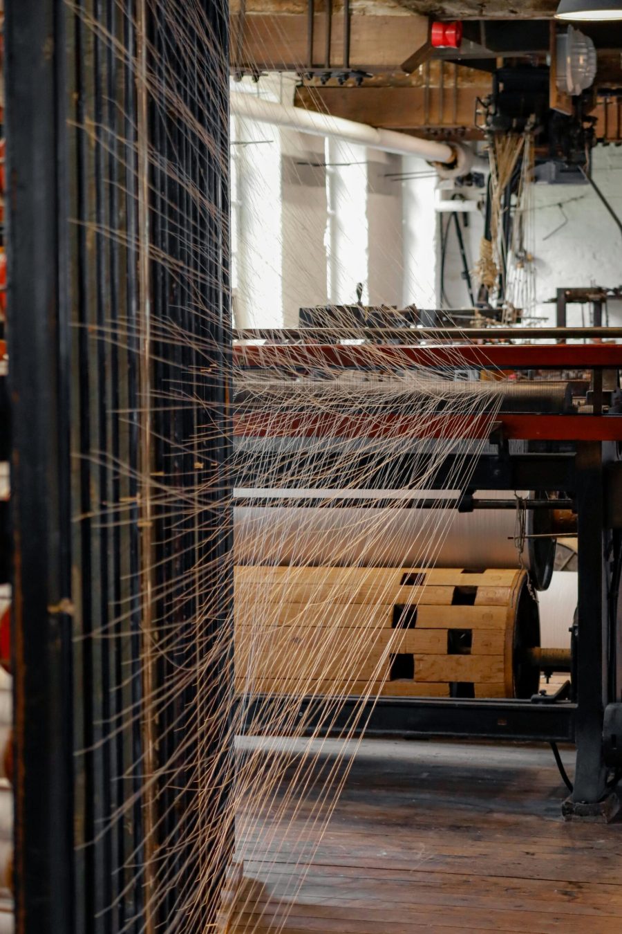 View inside a spinning mill with threads on machinery, showcasing modern textile production.